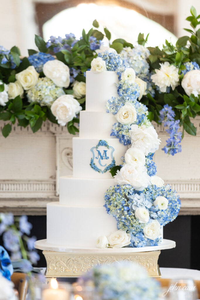 Tiered wedding cake with white roses and blue hydrangeas by Sage Fine Flowers