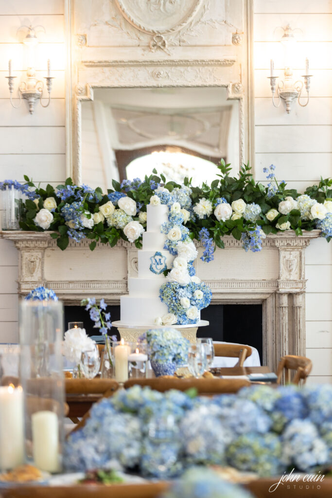 Blue and white florals on a cake table and mantel by Sage Fine Flowers